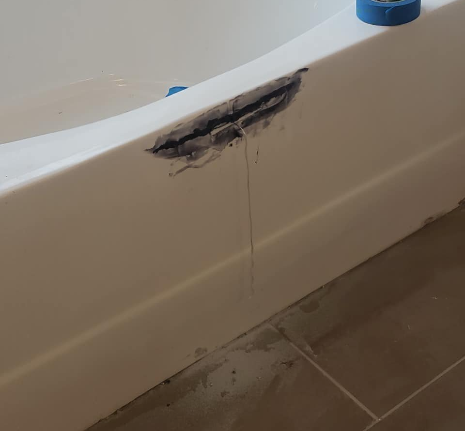 Bathtub with damage before repair